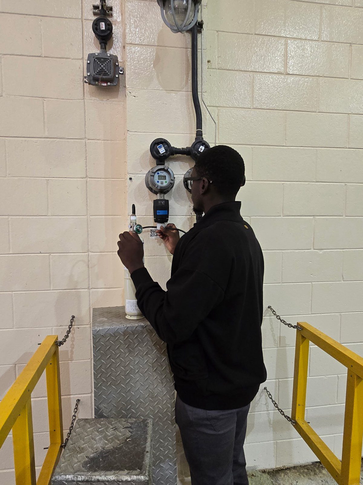 Technician adjusting wall-mounted utility meters